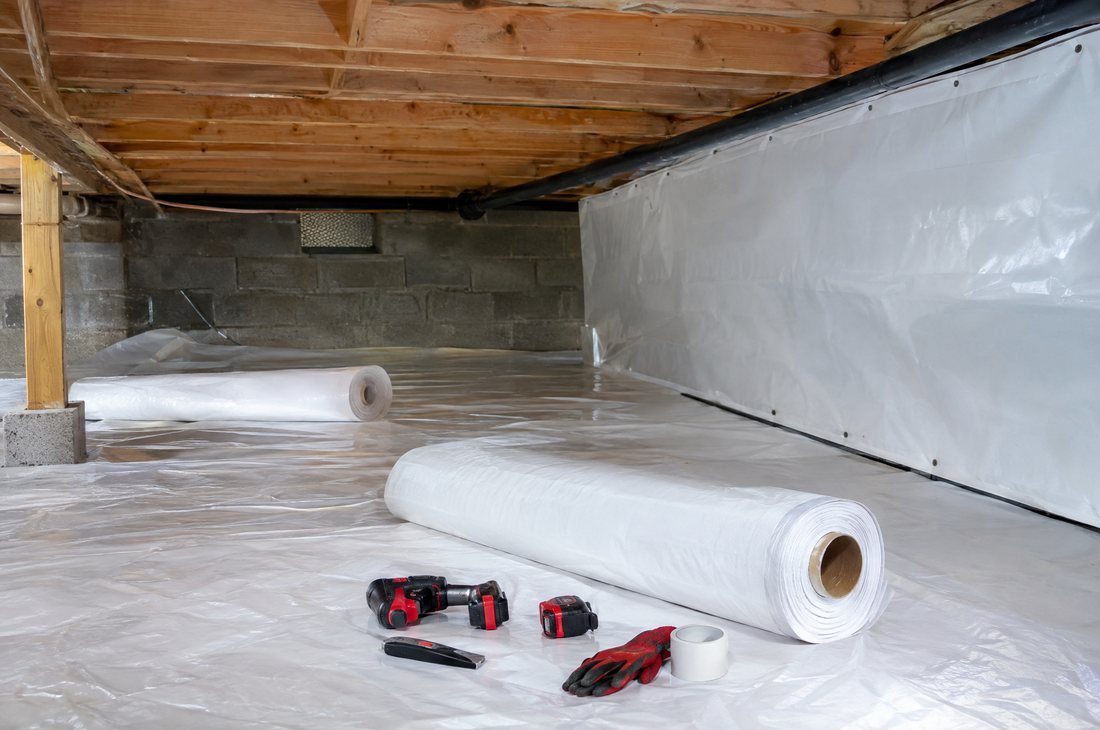 Vapor barrier and liner being installed across a Charlotte crawl space